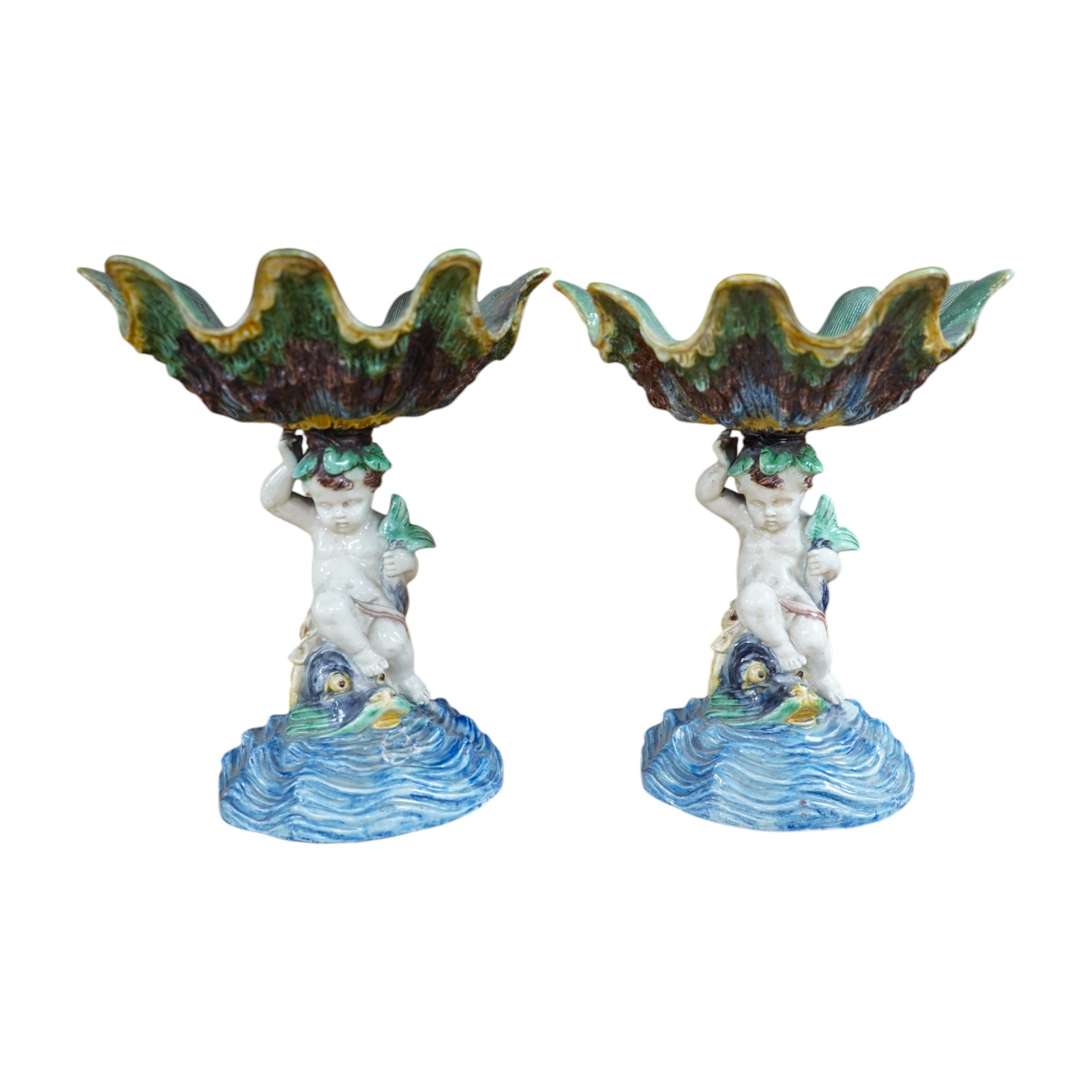 A pair of 19th century majolica comports with putti stems, 25cm. Condition - one repaired